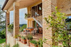 a house with a balcony with a table and chairs at Casa in Bioedilizia con Bio Piscina Naturale – Ai Due Gelsi in Grancona +35 photos
