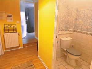 a bathroom with a toilet and a yellow wall at Chambres Les Salles in Beauvoir