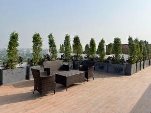 a patio with chairs and tables on a roof at Luxor Apartments & Suites - Opal in Lahore