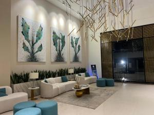 a large living room with couches and blue chairs at Luxor Apartments & Suites - Opal in Lahore