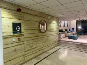 a lobby with a wooden wall with a sign on it at Luxor Apartments & Suites - Opal in Lahore +71 photos