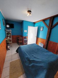 a bedroom with blue walls and a large bed at Chambres Les Salles in Beauvoir