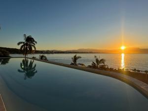 a swimming pool with a view of the ocean at sunset at Tizate Residents 202 in Cruz de Huanacaxtle