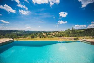 a blue swimming pool with a view of a mountain at Fattoria di Rignana in Greve in Chianti