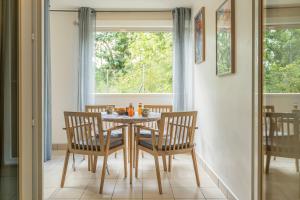 een eetkamer met een tafel en stoelen en een raam bij Le Nid - Cosy Plage & Confort - Wiskeys in Saint-Paul