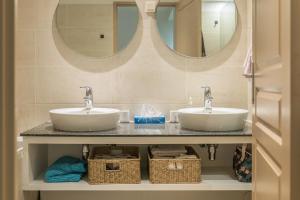 twee wastafels in een badkamer met twee spiegels bij Le Nid - Cosy Plage & Confort - Wiskeys in Saint-Paul +13 foto's