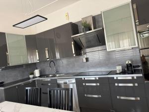 a kitchen with gray cabinets and a sink and a microwave at Casa Porta Mare in Rosolina +5 photos