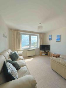 TV a/nebo společenská místnost v ubytování Bellevue, Apartment Overlooking Stunning Beach