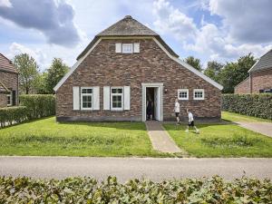 two people walking in front of a brick house at Farmhouse in Limburg near Designer Outlet in Roggel