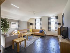 a living room with a couch and a tv at Farmhouse in Limburg near Subtropical Pool in Roggel