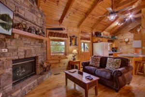 een woonkamer met een open haard in een blokhut bij Always and Forever in Sevierville