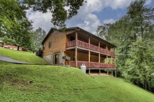 a wooden house on a hill with a green field at Bear Retreat in Sevierville
