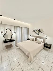 a white bedroom with a large bed in a room at Avenue Hotel Falassarna in Falasarna