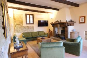 a living room with green couches and a fireplace at Casale Isidoro - Locazione Turistica 35159 in Castel Ritaldi