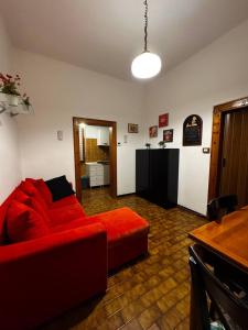 Casa Bella - Room 1 في البندقية: غرفة معيشة مع أريكة حمراء وطاولة
