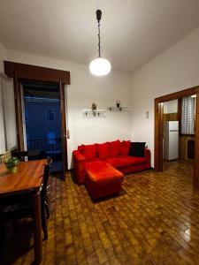Casa Bella - Room 1 في البندقية: غرفة معيشة مع أريكة حمراء وطاولة