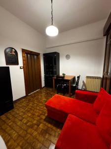 Casa Bella - Room 1 في البندقية: غرفة معيشة مع أريكة حمراء وطاولة
