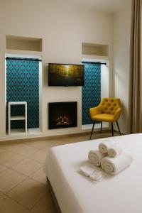 sypialnia z łóżkiem, krzesłem i kominkiem w obiekcie Garibaldi 118 Luxury Apartment w mieście Neapol