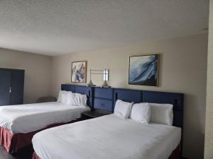 a hotel room with two beds with white sheets at Hamilton Inn Birmingham-Bessemer in Bessemer