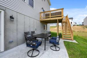 a patio with a deck and a table and chairs at Lunar Haven - Gorgeous 5 BDR in Walton
