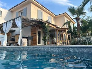 dom z basenem przed domem w obiekcie Roquebrune Golfs Plages w mieście Roquebrune-sur Argens