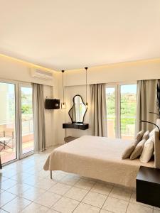 a bedroom with a large bed and a balcony at Avenue Hotel Falassarna in Falasarna +66 photos