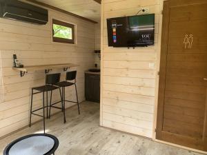 a room with two bar stools and a tv on the wall at Brvnara Carpe Diem in Usije