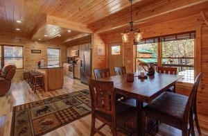 a dining room and kitchen in a log cabin at Pebblestone Lodge in Pigeon Forge