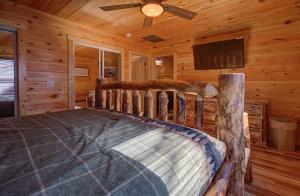 a bedroom with a bed in a log cabin at Pebblestone Lodge in Pigeon Forge +28 photos