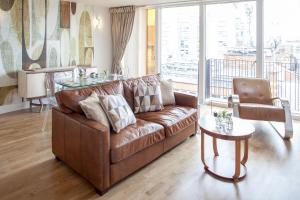 a living room with a brown couch and a glass table at The Sinclair Building in Sheffield
