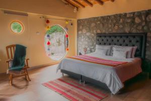 a bedroom with a large bed and a chair at Altipacha Valley Q Lodge in Quinua