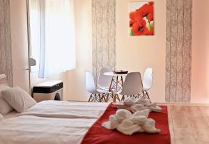 a bedroom with a bed and a table and chairs at Pipacs Apartman in Makó +41 photos