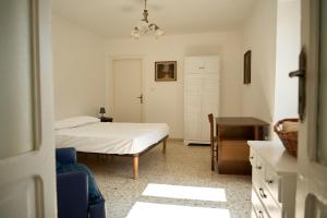 a bedroom with a bed and a desk and a chair at Casa Olimpia in Forio d'Ischia