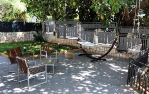 un patio con sedie, un tavolo e un'altalena di Villa Stesicoro Suite a Mondello