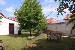 a bench in a yard with a tree and a building at Guest House Relax in Březí +10 photos