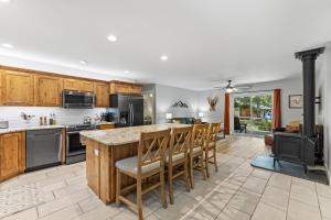 a kitchen with wooden cabinets and a island with chairs at Pineview on Baycolt- remodeled w/great parking, near downtown and golf course in McCall