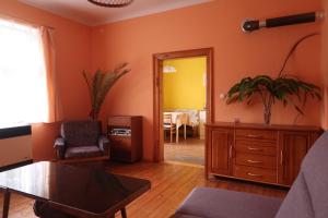 a living room with orange walls and a table at Guest House Relax in Březí
