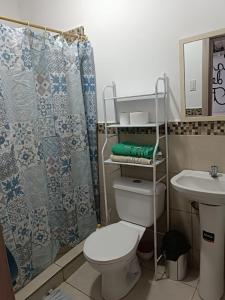 a bathroom with a toilet and a sink at La casa de las Flores in Manta
