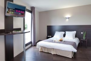 una camera d'albergo con un letto e una TV a schermo piatto di Logis Hôtel Terre de Loire a Belleville-sur-Loire Altre 59 foto
