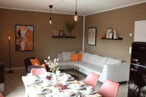 a living room with a table and a white couch at Komfort & Stil für Job & Reise - 6 Personen in Soltau