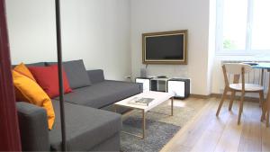 una sala de estar con un sofá y una mesa en Les Rochelais 12B, en La Rochelle