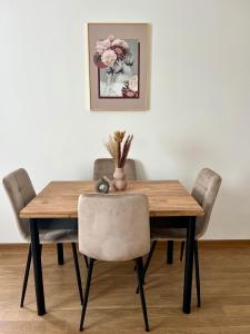 バニャ・ルカにあるLumière Apartmentの木製テーブル(椅子付)