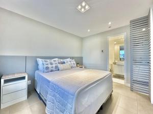a bedroom with a bed with blue and white sheets at São Paulo Ibirapuera Convention Plaza 02 Banheiros in São Paulo +26 photos