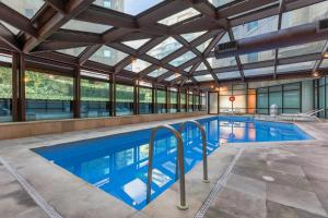 an indoor swimming pool with a ceiling with windows at São Paulo Ibirapuera Convention Plaza 02 Banheiros in São Paulo