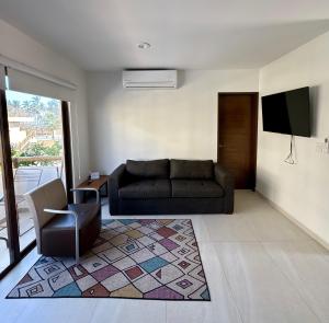 a living room with a couch and a tv at Fantástico Depa en Cerritos OCEANNA frente al MAR ! - 237 AB - in Mazatlán