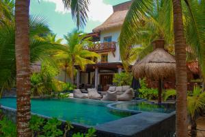 a resort with a swimming pool and palm trees at Delos Luxury Villa in Uaymitun