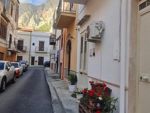 an alley with buildings and potted plants and a mountain at Casa vacanze Andry in Cinisi