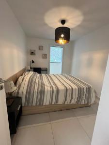 a white bedroom with a bed and a window at Briançon au pied des pistes in Briançon
