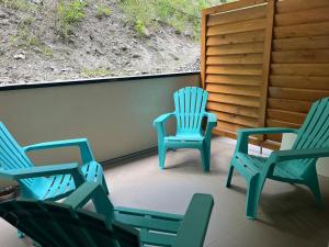 three blue chairs sitting on a porch next to a wall at Briançon au pied des pistes in Briançon