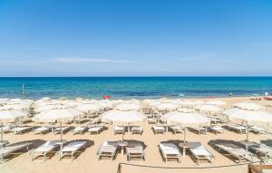 a beach with chairs and umbrellas and the ocean at Cozy Home In Capaccio in Foce del Sele +26 photos